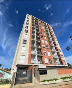 a tall apartment building with a blue sky in the background at Departamento de 1 habitación con amenities, cerca del eje corporativo in Fernando de la Mora