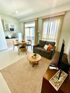 a living room with a couch and a tv and a table at Departamento de 1 habitación con amenities, cerca del eje corporativo in Fernando de la Mora