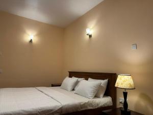 a bedroom with a bed and two lights on the wall at Lake View By IJ in Nuwara Eliya