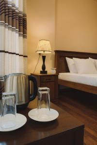 a bedroom with a bed and two glasses on a table at Lake View By IJ in Nuwara Eliya
