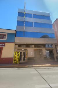 a blue building with a yellow sign in front of it at HOSTAL ACUARIUS PUNO in Puno