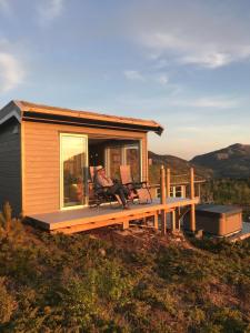a tiny house on a hill with a deck at Cabin with stunning views and outdoor jacuzzie in Leset