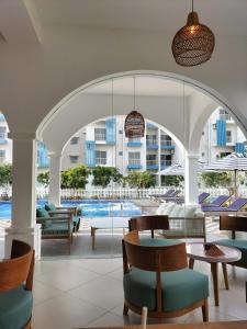 an outdoor patio with tables and chairs and a pool at Santorini Resort Apartment 3 Bed rooms- Negombo Beach & Airport in Negombo