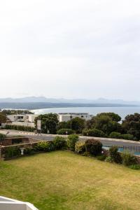 a view of a building with a road and a body of water at Seascape Plettenberg Bay in Plettenberg Bay