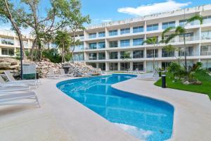 una piscina di fronte a un edificio di Estudio Balaam a Playa del Carmen