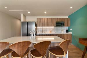 una cucina con isola e sgabelli in legno di Estudio Balaam a Playa del Carmen