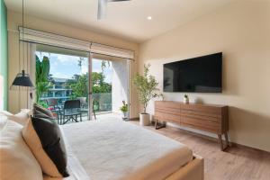 una camera da letto con un letto grande e una TV a schermo piatto di Estudio Balaam a Playa del Carmen