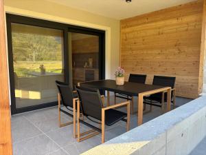 a dining room with a black table and chairs at Haischberger Apartments in Obertraun