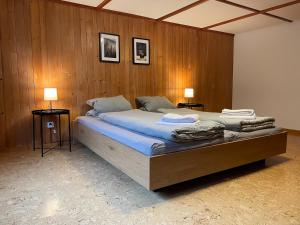 a bedroom with a large bed with wooden walls at Apartment HasliView in Innertkirchen