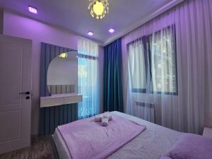 - une chambre violette avec un lit et un miroir dans l'établissement Premium apartment in Batumi 1718, à Batoumi