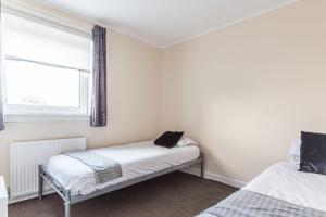 a room with two beds and a window at Charming Livingston Home with Garden in Uphall
