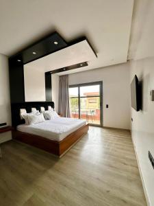 a bedroom with a large bed and a large window at 5-star luxury villa with private pool in Marrakech