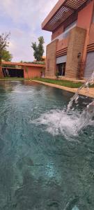 a pool of water in front of a house at 5-star luxury villa with private pool in Marrakech