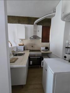 a kitchen with white cabinets and a counter top at Monte G Sea View in Monte Gordo