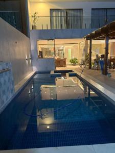 einem Pool in einem Gebäude mit eingeschalteten Lichtern in der Unterkunft Sanzecasadapraia in São José da Coroa Grande