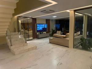 eine Lobby mit einer Treppe und einem Wohnzimmer in der Unterkunft Sanzecasadapraia in São José da Coroa Grande