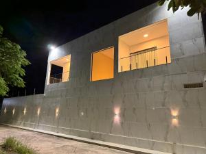 ein Blockgebäude mit Lichtern in der Nacht in der Unterkunft Sanzecasadapraia in São José da Coroa Grande