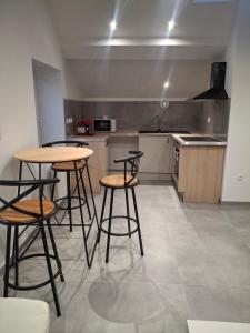 a kitchen with two tables and two stools at Appartement loft in Mandeure