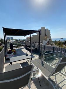 Un patio con una mesa y sillas en un tejado. en Luxury Sea View Penthouse, en Herzliya