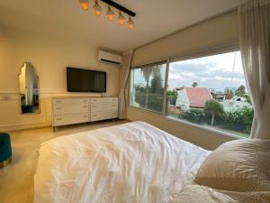 Un dormitorio con una cama y una ventana grande. en Luxury Sea View Penthouse, en Herzliya