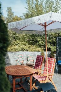 a wooden table and two chairs and an umbrella at Kindvriendelijk vakantiehuis in Winterberg met tuin - Modern & rustig gelegen in Winterberg