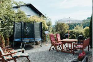 a patio with chairs and a table and an umbrella at Kindvriendelijk vakantiehuis in Winterberg met tuin - Modern & rustig gelegen in Winterberg