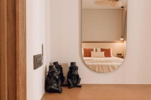 a mirror on a wall next to a bedroom at Nuvélia, A Minimalist Luxury Story in Zakynthos Town
