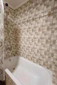 y baño alicatado con bañera blanca. en Confortable cabaña de campo, en Coyhaique