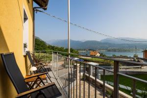 a balcony with chairs and a view of the water at L'Acero Sublime Guesthouse in Feriolo