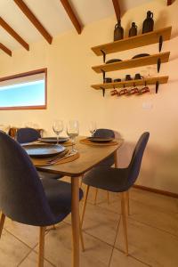 un comedor con una mesa con sillas y copas de vino en Confortable cabaña de campo, en Coyhaique