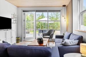 un salon avec un canapé bleu et une table dans l'établissement LF303-Hurup-Thy-Helligsovej-3, à Sønder Ydby