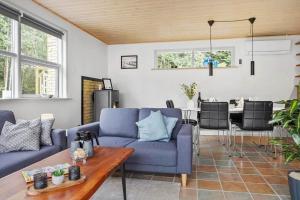 un salon avec un canapé bleu et une table dans l'établissement LF303-Hurup-Thy-Helligsovej-3, à Sønder Ydby