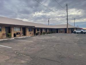 a building with a car parked in a parking lot at Sands Motel in Van Horn