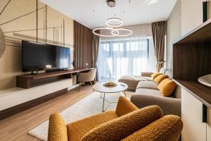 Maison Lumière - A modern Designer Apartment in Central Bucharest في بوخارست: غرفة معيشة مع أريكة وتلفزيون
