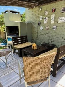 a patio with a table and chairs and a wall at La Casita in San Antonio de Areco