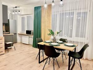 a kitchen and dining room with a table and chairs at New Stylish Apartment City Center Self Check-In in Narva