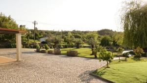 a garden with trees and grass and a pavilion at Casa da Biquinha in Vouzela