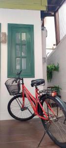 a red bike parked in front of a green door at Carl and Ellie Home in Bangkok