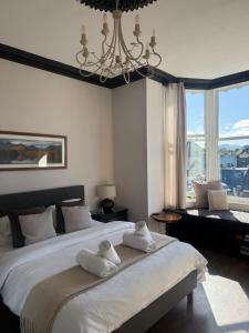 a bedroom with a large bed with towels on it at Shemara rooms in Keswick