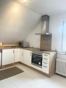 a kitchen with white cabinets and a stove top oven at Grille Apartment Minden in Minden