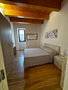 a bedroom with a large bed and wooden floors at La Locanda del Barone in Torraca