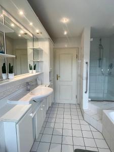 a white bathroom with two sinks and a shower at Grille Apartment Minden in Minden