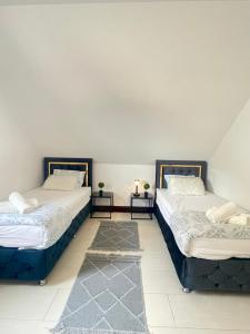 two beds in a room with two tables at Grille Apartment Minden in Minden