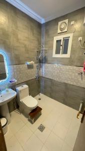 a bathroom with a toilet and a sink at إستراحة البستان in Ash Shuwaybiţ