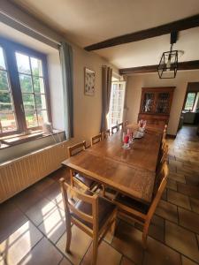 バゼイユにあるGite rural Lamécourt - 12 personnesの木製のテーブルと椅子のあるダイニングルーム