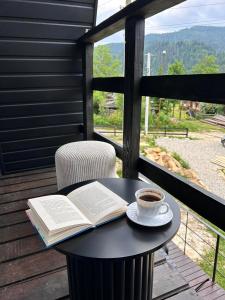 a book and a cup of coffee sitting on a table at Diamond chalet A-frame in Ogrody