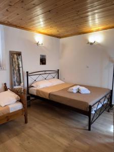 a bedroom with two beds and a wooden ceiling at Tsakoniki filoxenia! in Leonidio