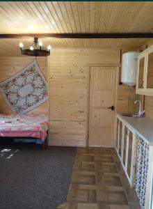 Una pequeña habitación con una cama y una cocina. en Келечин 95, en Kelechin