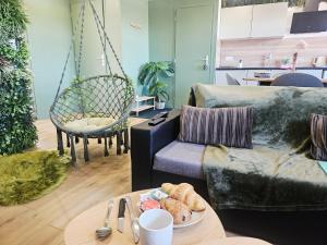 a living room with a couch and a table with a plate of food at Appart 7Om2 Atypique "Forêt enchantée" tout confort à 20 minutes de Lille et Arras in La Bassée +27 photos