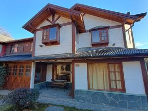 a house with a porch with a roof at Casa Sueño in San Martín de los Andes